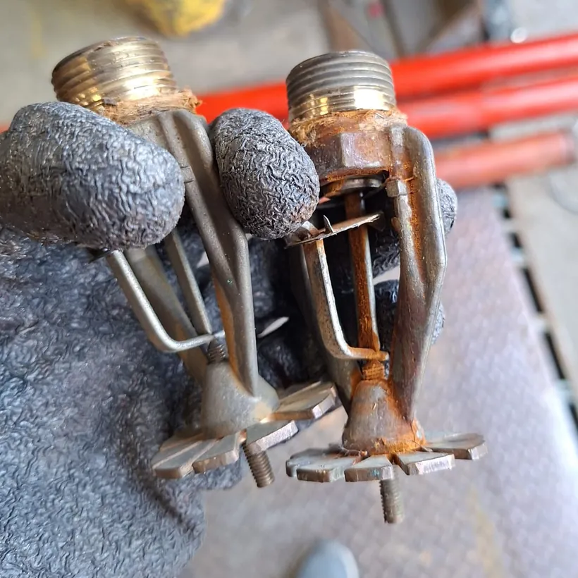 Deux têtes de sprinkler déposées côte à côte : l'une en bon état, l'autre fortement corrodée